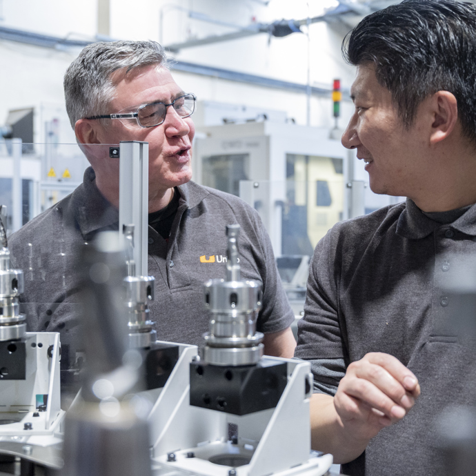 men discussing project in front of a machine in the factory